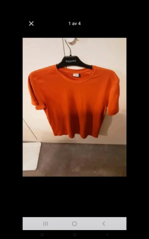 Orange t-shirt från KappAhl - Snygg orange t-shirt från KappAhl med klassisk rund hals och korta ärmar. Perfekt enkel stil och skön passform, tillverkad i mjuk bomull. Passar dig som gillar färg och vill ha en basic tee med lite edge.