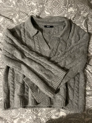Grå stickad tröja från Bik Bok - Mysig grå stickad från Bik Bok med kabelstickat mönster. Storlek S