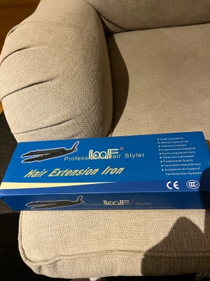 loof Professional Hair Extension Iron - Professionell hårförlängnings-tång från loof, ergonomiskt designad med extra lång 2,5m svivelkabel. Snabb uppvärmning, lätt och smidig att använda. Passar alla hårförlängningssystem. Produkten och förpackningen är i gott skick, endast lätt slitage på kartongen.