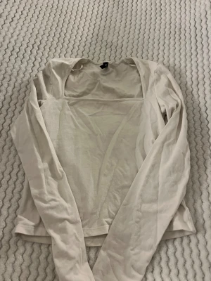 Vit långärmad topp från H&M Divided - Vit långärmad croptop ifrån H&M i storlek S.