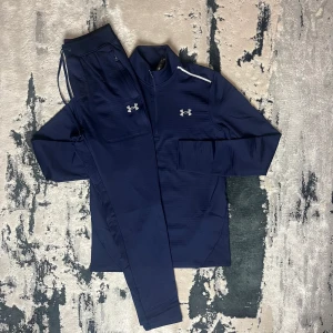 UNDER ARMOUR - CW FLEECED TRACKSUIT - Under Armour – CW Fleeced Tracksuit • Kofta och byxa i matchande färg • Storlekar från XS till 2XL • Går också få den på sneaks,se