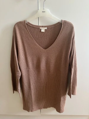 Beige/kamel ribbad tröja v-ringad - Snygg ribbad beige/kamel tröja från H&M med v-ringad hals och trekvartsärm. Perfekt för dig som gillar en enkel men stilren look