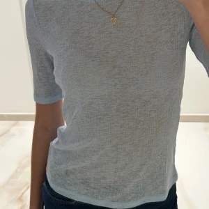Ljusblå lätt genomskilnig topp - T-shirt som är lite genomskilnig med halvlånga ärmar.