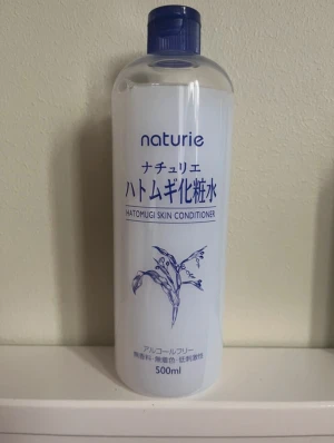 Naturie Hatomugi Skin Conditioner - Stor flaska med 500 ml av Naturie Hatomugi Skin Conditioner, en toner som är alkoholfri och passar för att återfukta huden. Flaskan är transparent med blå text och har en blå skruvkork. Perfekt för att ge huden extra fukt och fräsch känsla. Kontakta för prisförslag också