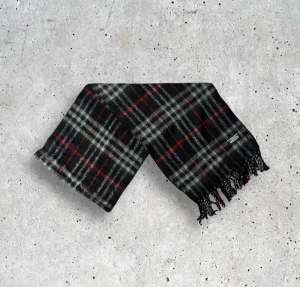 Svart burberry halsduk - Säljer en elegant Burberry-halsduk i en stilren, tidlöst svart färg med det ikoniska rutmönstret. Tillverkad i 100% mjuk och värmande ull som ger en lyxig känsla och håller hög kvalitet. En perfekt accessoar som passar till allt och lyfter både vardags- och kvällsoutfits.  🧵 Skick: Mycket fint skick, varsamt använd 🌟 Känsla: Mjuk, varm och följsam 📦 Frakt: Skickas tryggt inom 24h 📏 Mått: Längd-170cm, Bredd-30cm Pris kan diskuteras!