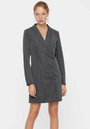 Vero Moda strl 36 glittrig nyårsklänning nyår fest klänning - Supersnygg kort omlottklänning i silver glittrigt tyg med v-ringning och långa ärmar. Klänningen har en kavajliknande design och markerad midja som ger en cool och dressad look. Perfekt för dig som vill sticka ut med stilren vibe. Strl 36
