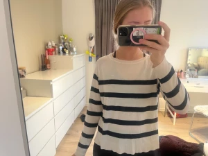 Randig beige och svart tröja från Zara strl S - Säljer en snygg beige och svart randig tröja från Zara i storlek S. Tröjan har rund halsringning och långa ärmar. Den är stickad i mjuk bomull och har en klassisk, normal passform som är enkel att matcha med jeans eller kjol. 