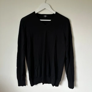 Mörkblå v-ringad tröja från Uniqlo - Mörkblå v-ringad tröja från Uniqlo i ren ull. Klassisk och stilren design med långärmade ribbade muddar och mjuk känsla. Perfekt för dig som gillar enkel och clean look. Storlek L. 4Ä19