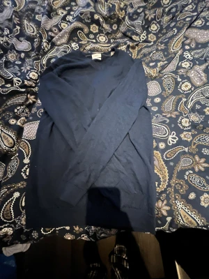 Mörkblå merinoulltröja från Esprit - Snygg mörkblå stickad tröja från Esprit i ren merinoull. Klassisk rund hals och långärmad modell som är perfekt för kyliga dagar. Enkel och stilren design som funkar till jeans eller chinos. Storlek S, mjuk och skön känsla mot huden.