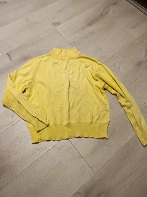 Gul polotröja  - Snygg ljusgul polotröja från Åhlens i storlek 34/36. Tröjan har ribbad krage och muddar, är långärmad och tillverkad i mjukt stickat material. Perfekt för dig som gillar stilrena och färgglada plagg med enkel design. Den passar dock mindre storlekar som 160-xxs