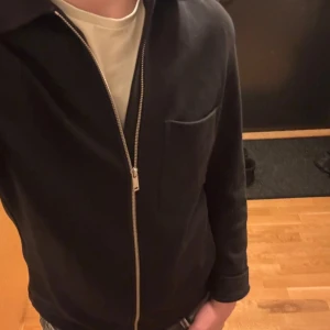 Overshirt från COS - Säljer en stilren svart overshirt från Cos. Den är i väldigt fint skick!