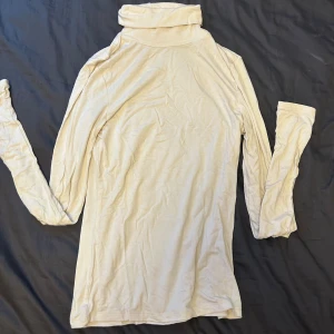 Beige polotröja i bomull XS - Säljer en stilren beige polotröja i mjuk bomull. Tröjan har lång ärm och en klassisk hög krage som ger en clean look. Perfekt att styla med jeans eller kjol för en enkel men snygg outfit.