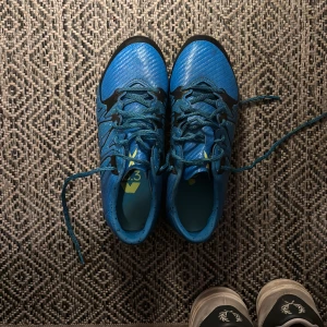 Blå fotbollsskor med snöring - Säljer ett par blå fotbollsskor med svarta detaljer och snörning. Skorna säljs pågrund utav att de är för små för mig.