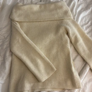 Ribbad offshoulder tröja från H&M - Säljer en ribbad offshoulder tröja från H&M i mjuk, stickad ullblandning. Färgen är ljus beige och modellen har långa ärmar och bred krage som kan bäras offshoulder