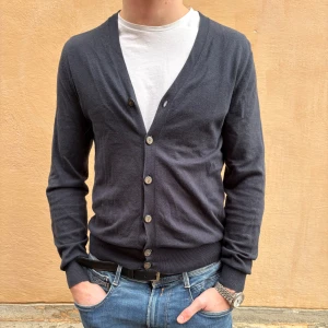 003 marinblå kofta  - En snygg marinblå kofta ifrån Massimo Dutti med vringning runt halsen. Perfekt att slänga över en vit T-shirt eller skjorta för en clean och avslappnad look. 