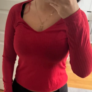 Röd ribbad långärmad topp Lindex - Säljer en snygg röd långärmad topp från Lindex i storlek S. Toppen har ribbad struktur och en v-ringad hals som ger en schysst look. Materialet är mjukt och stretchigt, perfekt för dig som gillar bekväma och stilrena plagg.