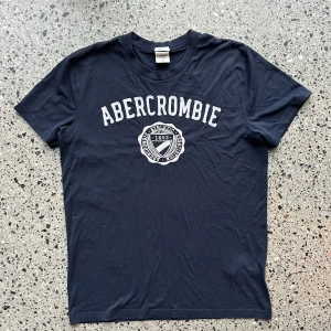 Abercrombie & Fitch T-shirt - Snygg marinblå T-shirt från Abercrombie & Fitch i mycket bra skick!