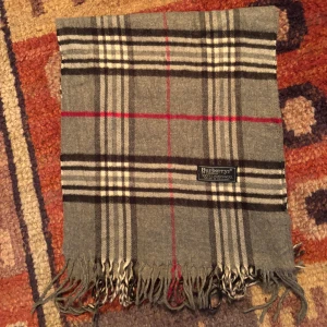 Vintage Burberry Halsduk Scarf - -Riktigt bra skick. Nypris på dessa ligger på runt 5000kr, vilket gör detta till ett sjukt bra pris! Halsduken är gjord i Lamull, och är perfekt inför hösten och den kommande vintern. Anledningen till att det står ”Burberry’s” och inte ”Burberry” på lappen är eftersom halsduken är från några år tillbaka, innan de bytte namn! Om du har någon fråga är det bara att skriva till mig. /elgnce (4)