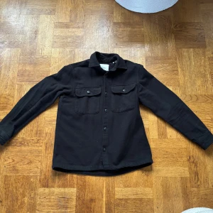Svart overshirt  - Svart overshirt från Jack & Jones i storlek M. Skjortan har två bröstfickor med knappar, 
