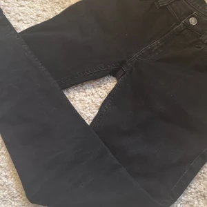 Svarta skinny jeans från Nudie Jeans - Svarta jeans från Nudie Jeans med klassisk femficksdesign och snygga detaljer på bakfickorna. Modellen är skinny med smal passform och midwaist. Materialet är jeans med en mjuk känsla och diskret tvättad look. Perfekt för dig som gillar stilrena och tajta jeans.