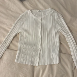 Vit ribbad kofta från H&M - Säljer en vit ribbad kofta från H&M. Koftan ärlångärmad. Storlek 158-164. Har aldrig använt tröjan då den är i nytt skick. Köptes för cirka 200