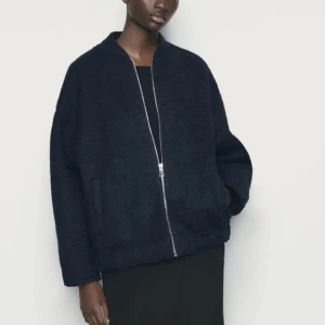 Svart teddyjacka med dragkedja - Säljer en svart teddyjacka med oversized passform och lång ärm. Jackan har en stilren design med silverfärgad dragkedja framtill och mjukt, fluffigt material som ger en cool look. Jackan är använd och lite nopprig 