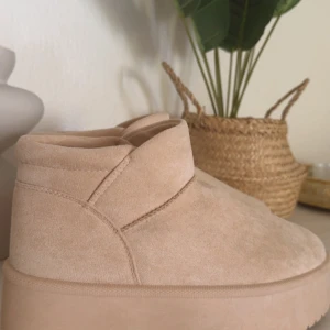 Beige boots från Shein med platåsula - Säljer ett par beige boots från Shein med mjuk mockaliknande yta och plattformsula. Skorna har rund tå och grovt mönstrad yttersula för extra grepp. Insidan är fodrad för extra komfort och värme. Perfekta för dig som gillar stilrena och trendiga skor.