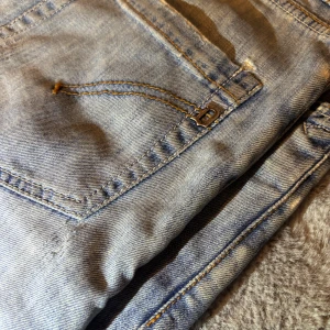 Dondup jeans  - Säljer ett par ljusblå Dondup jeans med klassisk femficksdesign och snygga slitningar. Jeansen har raka ben och normal passform. De är i okej skick pga patchingar inne i byxan (märks knapt av) och har en riktigt fet wash. Säljs nu för ett riktigt bra pris! De sitter som 30/32 