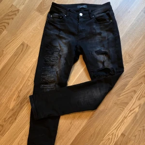 Amiri jeans - Svarta jeans från Amiri med slim fit passform och slitningar på benen. Snyggt broderad Amiri logga längs ena benet och klassisk femficksdesign. Jeansen är tillverkade i stretchig bomull och har en cool, mörk tvätt med distressed detaljer. Helt nya! Riktiga