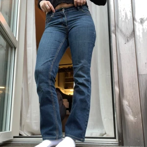 Blå bootcut jeans med låg/medelhög midja - Snygga blå jeans med bootcut passform och medelhög/låg midja. Klassisk femficksmodell med gul kontrastsöm och stretchigt jeanstyg som sitter skönt. Perfekt för dig som gillar en tidlös look med lite utsvängda ben. Passar den med lite kortare ben då de är lite korta på mig (170cm), så perfekt om man är kortare än så!!