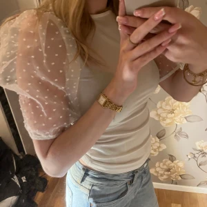 Vit blus med puffärm från Gina Tricot - Supersöt vit blus från Gina Tricot i storlek XXS. Toppen har puffiga, transparenta kortärmar med prickigt mönster och rund halsringning. Kroppen är i mjukt tyg och ärmarna ger en extra touch med sin volym och prickar. Perfekt för dig som gillar romantisk stil.