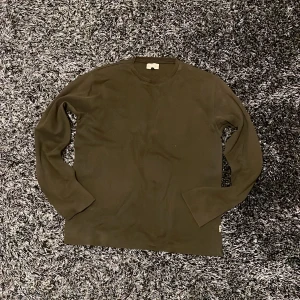 Mörkbrun långärmad tröja Jack & Jones - En stilren mörkbrun långärmad tröja från Jack & Jones. Tröjan har en klassisk rund halsringning och är tillverkad i mjukt bomullsmaterial. Perfekt för lager-på-lager och enkel att matcha med jeans eller chinos.