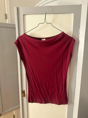 Vinröd topp från Nelly - En enkel och stilren vinröd topp från Nelly i mjuk bomull. Modellen är ärmlös med bred halsringning och har en tight passform som framhäver siluetten❣️