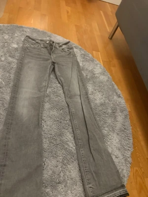 Grå jeans från Gina Tricot, storlek 170 - Säljer ett par grå jeans från Gina Tricot i storlek 170. Jeansen har klassisk femficksdesign, raka ben och normal passform. Perfekta för dig som gillar en enkel och stilren look. Materialet är mjukt och bekvämt jeans.