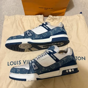 Louis Vuitton Trainers - Snygga sneakers från Louis Vuitton. Perfekt för den som vill ha en stilren och exklusiv look. Nypris cirka 13000 SEK. Storlek 13,5 vilket motsvarar cirka 47. Bra skick förutom ett hål ett av skosnörshålen.   Påse och dustbag ingår. Vid frågor kontakta mig!