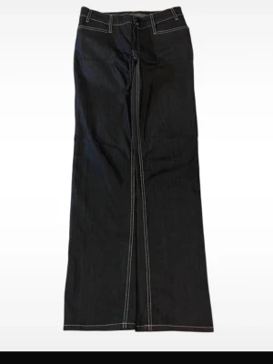 Svarta/mörkblå raka jeans från Comma - Säljer ett par svarta/mörkblå jeans från Comma i storlek 38. Byxorna har breda ben markerade vita sömmar och två bakfickor med lock och knapp. Måtten är 105 cm i längd totalt, midja 39cm, lår:27cm, innersöm:18,5cm. 