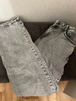 Grå jeans ”Stella” från Lindex - Säljer ett par grå tvättade jeans från Lindex, modell Stella i storlek 164. Jeansen har justerbar midja med knappresår. Materialet är jeans i bomull och passformen är rak och lite baggy.