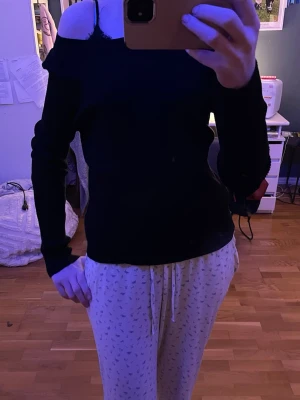 Svart ribbad långärmad topp Kappahl - En svart, ribbad långärmad topp från Kappahl. Modellen har rund halsringning och sitter löst på mig som har storlek xs/s i vanliga fall, stretchigt tyg.