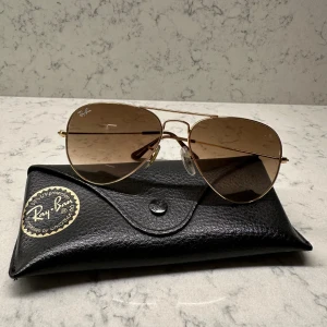 Solglasögon från RayBan - Fina solglasögon från RayBan i brunt fadeat/ombre glas. Guldfärgad ram. Fordralet följer med! 🤎