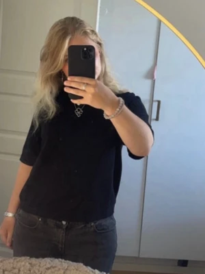 Svart basic finstickad t-shirt  - Enkel svart t-shirt med korta ärmar och rund hals. T-shirten har en normal passform och är finstickad, perfekt till jeans eller shorts. Stilren och lätt att matcha med andra plagg.