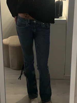 Blå bootcut jeans med broderade fickor - Säljer ett par blå jeans med bootcut-snitt och snygga broderade detaljer på bakfickorna från Gina Tricot. Jeansen har låg midja💞💞