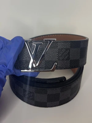 L bälte grå rutig - Helt nya oanvända bälten i olika märken, modeller och färger! Kommer bra packat samt med ett litet verktyg som du enkelt kan göra hål med ifall du skulle behöva det. Vi postar allas ordrar inom 24h för att du ska få ditt paket så fort som möjligt! Använd helst instabox men PostNord funkar också! 