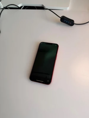 Det här är en iPhone 13.  - Det här är en iPhone 13. Jag har bytt batteriet på den, och batteriet är originellt och fungerar bra. Bakkameran är också originell. Det finns en spricka bakom telefonen, men bakkameran fungerar perfekt, inga problem — det kan jag garantera. Jag kan också garantera att batteriet är bra.  Jag kan mötas i Göteborg eller Varberg, och jag kan även skicka den med frakt