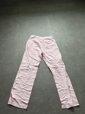 Ljusrosa linnebyxor från 157 - Säljer ett par ljusrosa linnebyxor från 157 med elastisk midja och dragsko. Byxorna har raka ben och sidofickor, perfekta för chill dagar. Materialet är svalt och luftigt linne som ger en avslappnad vibe. (De är lite mer rosa u verkligheten än på bilderna) 