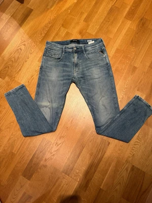 Replay ljusblå jeans  - Säljer ett par ljusblåa anbass jeans från Replay med små snygga slitningar. Mjuka och sköna i slimfit modell. Storlek 32 32!