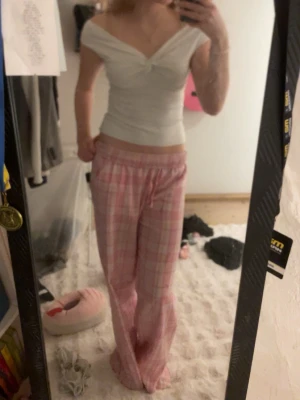 Vit omlott topp med twistad detalj - Säljer en vit omlott topp med snygg twistad detalj framtill. Toppen har offshoulder-design och är figurnära med korta ärmar. Materialet känns mjukt och stretchigt, troligen bomull eller polyester. Perfekt till jeans eller kjol för en clean look.