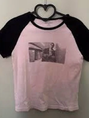 Brandy Melville svartvit t-shirt med Leon filmen motiv - Säljer en svartvit t-shirt från brandy med kontrastfärgade svarta ärmar och ett grafiskt tryck (Léon filmen) framtill. Aldrig använd! Klassisk baseballmodell med rund hals och korta ärmar. Perfekt för dig som gillar streetstyle och vill sticka ut lite extra.