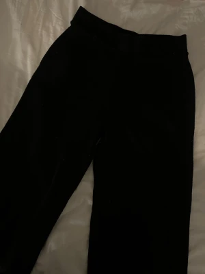 Svarta fin -stickade byxor Gina Tricot  - Säljer ett par svarta fin-stickade byxor från Gina Tricot.  Byxorna har rak passform men sitter tajtare på höften och har elastisk midja för extra komfort. 