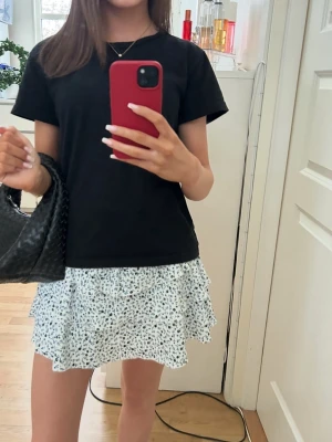 Vit blommig volangkjol - Zara kjol. Knappt använd!  Storlek 13-14 år. Skulle säga det är som en vanlig Xs. Shorts under kjolen.