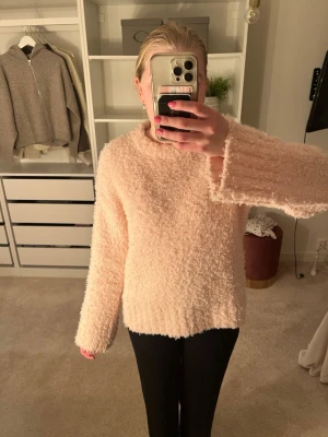 Ljusrosa fluffig stickad tröja H&M - Supermjuk och fluffig ljusrosa stickad tröja från H&M. Tröjan har rund hals, långa ärmar och ribbade muddar vid ärmslut och nederkant. Perfekt för kalla dagar när du vill vara både cozy och snygg.